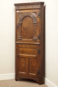 Early 20th century carved oak floor standing corner cupboard, carved strap work, panelled cupboards,