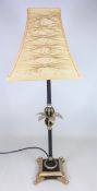 Gilt table lamp with palm leaf decoration on scroll feet, H64.