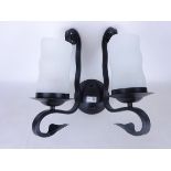 Set of eleven black finish wrought metal single branch light fittings with opaque glass shades,