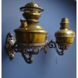 Pair of Victorian ornate wrought iron oil lamp wall sconces, with two brass oil lamps and funnels,