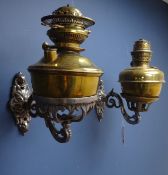 Pair of Victorian ornate wrought iron oil lamp wall sconces, with two brass oil lamps and funnels,