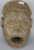 Tribal Masks; African carved wood mask of a male face,