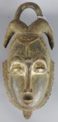 Tribal Masks; West African carved wood mask, highlighted with traces of white and red pigment,