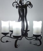 Black finish wrought metal six branch light fitting with opaque glass shades,