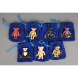 Seven miniature Steiff painted cast metal jointed bears, with original pouches,