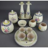 Three Poole pottery condiment jars, oil and vinegar bottles on stand, egg cup set,