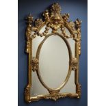 Ornate gilt finish wall mirror, oval centre, decorated with foliage and cherubs, W90cm,