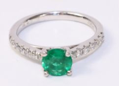 Platinum ring set with an emerald and seven diamonds to each shoulder hallmarked