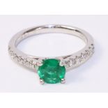 Platinum ring set with an emerald and seven diamonds to each shoulder hallmarked