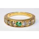 18ct gold ring set with six diamonds and a central emerald hallmarked