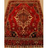 Persian Bakhtiari red ground rug, stylised design, large central pole medallion,