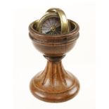 A ships compass with floating brass holder in 3 1/2" turned oak stand G+