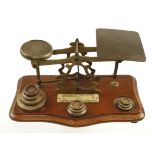 A 19c brass postal scale with list of charges eg 1 oz.