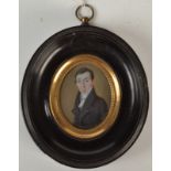 A George III portrait miniature of a gentleman, his blue coat with high collar,