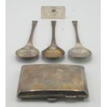 Three silver collectors spoons, a silver ingot and a silver cigarette case.