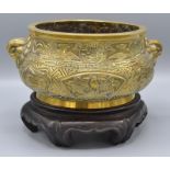 A Chinese bronze censer, 19th century, decorated with fan shaped panels with a reclining figure,