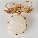 A 9ct. gold bow brooch suspending a large white opal.