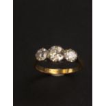 A three stone diamond ring set in platinum and 18ct. gold.