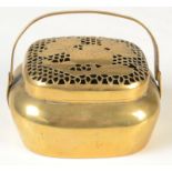 An oriental metal hand warmer, the pierced cover decorated with fruiting pomegranates,