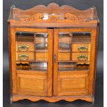 A late Victorian or Edwardian smokers cabinet with an arrangement of niches under drawers behind