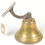 A brass bell with metal bracket, height 15.5cm.