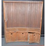 An Arts and Crafts elm settle, the bowed back with narrow cedar planks,