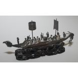 A Chinese cast and worked iron model of a ceremonial Dragon boat controlled and rowed by a crew of
