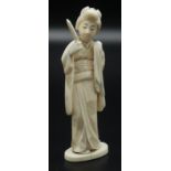 A Japanese walrus ivory okimono, a Geisha standing holding a mirror,