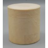 A cylindrical ivory box with hinged lid.