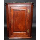 A George III oak hanging corner cupboard with crossbanded, fielded panelled door.