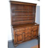 A pine dresser in George III style and possibly of the period, the upper section with open shelf,