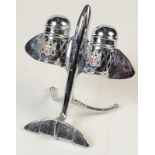 A chrome aeroplane cruet, the cellars each with an enamelled London crest and blue glass liner,