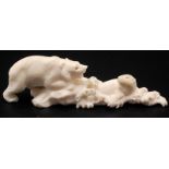 A Japanese ivory okimono of a polar bear chasing a seal as it breaks through waves.