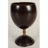 A 19th century coconut cup with bone stem, height 13.5cm.