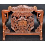 A 19th century Chinese carved hardwood panel, with later added feet,