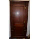 A mahogany standing corner cupboard in George II style with fluted and dentilled cornice,