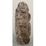 A carved stone figure of a grotesque seated man, height 13cm.