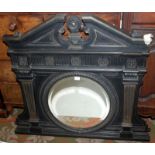 An iron overmantle cast as a circular mirror flanked by pilasters, width 104cm, height 105cm.