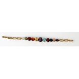 A gold bracelet set eleven various graduated semi precious stones.