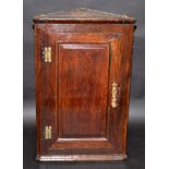 A small hanging oak corner cupboard, in 18th century style with single fielded panel door.