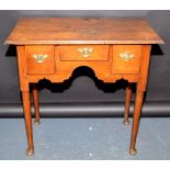 An 18th century oak lowboy with three small drawers over triple arch apron,