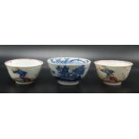 A pair of Chinese famille rose tea bowls decorated with figures in a garden scene with birds and