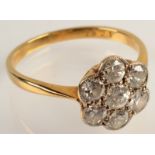 A seven stone diamond flowerhead cluster ring.