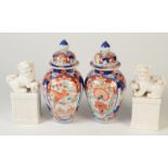 A pair of late 19th/early 20th century Japanese Imari baluster vases and covers decorated with a