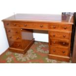 A mahogany veneered twin pedestal desk, the top with red leather inset.