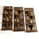 A set of three Chinese brown lacquered and gilt decorated wall shelves decorated with warriors on