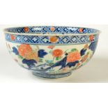 A Japanese Imari deep bowl, decorated with kiku, peonies and other symbolic flowers between rocks,