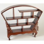 A Chinese hardwood display stand, 20th century, the four shelves with numerous sections,