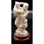 A Japanese ivory okimono, a standing figure of a father with his two young sons,