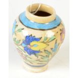 A Persian pottery baluster vase, decorated with flowering leafy vines, height 12cm.